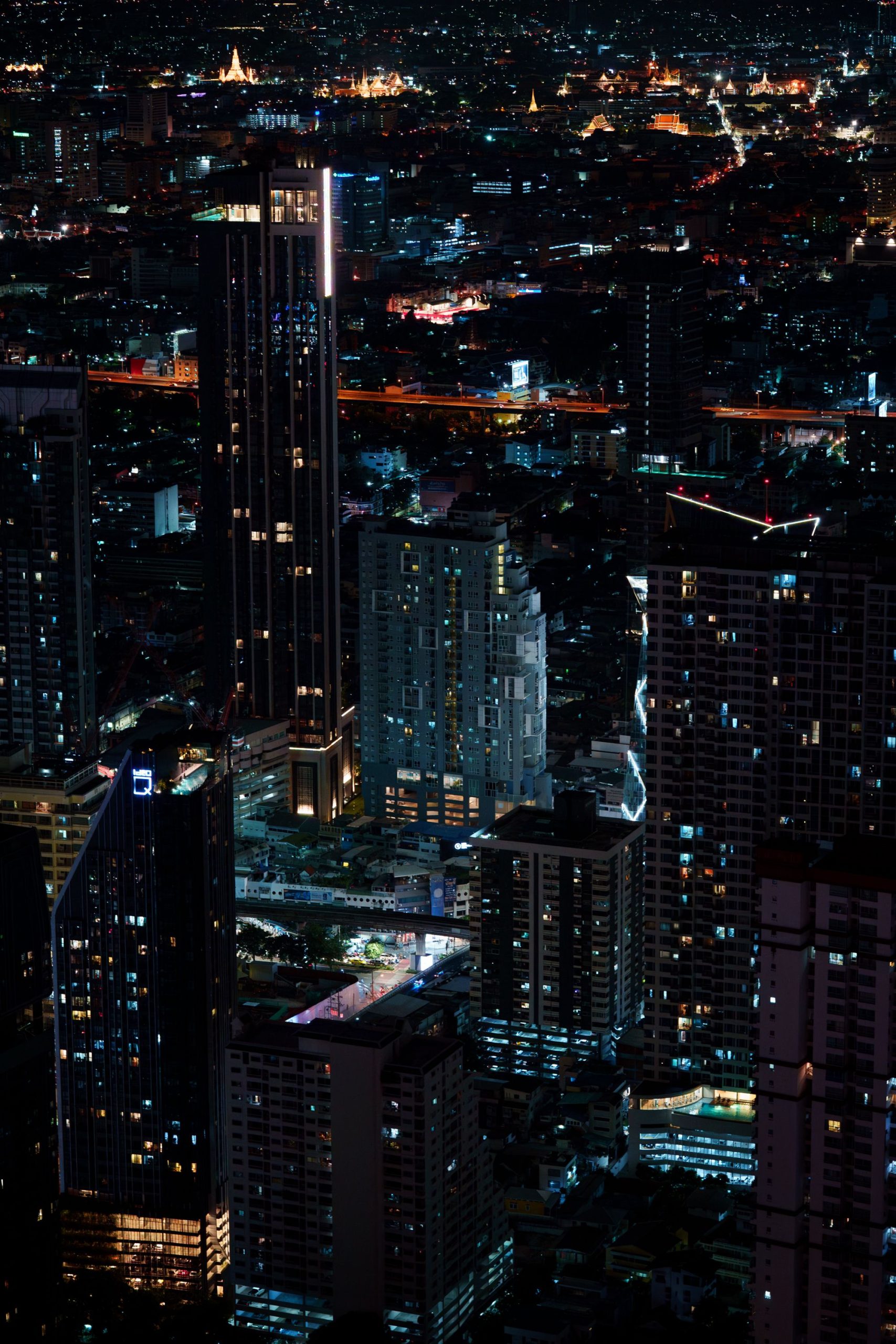 Stunning night view of Bangkok's illuminated cityscape with towering skyscrapers and vibrant lights.