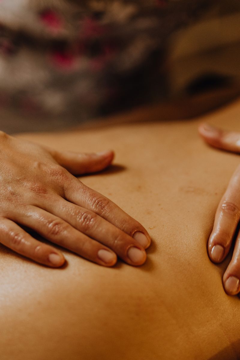 Close-up of hands giving a soothing back massage in a calm setting.